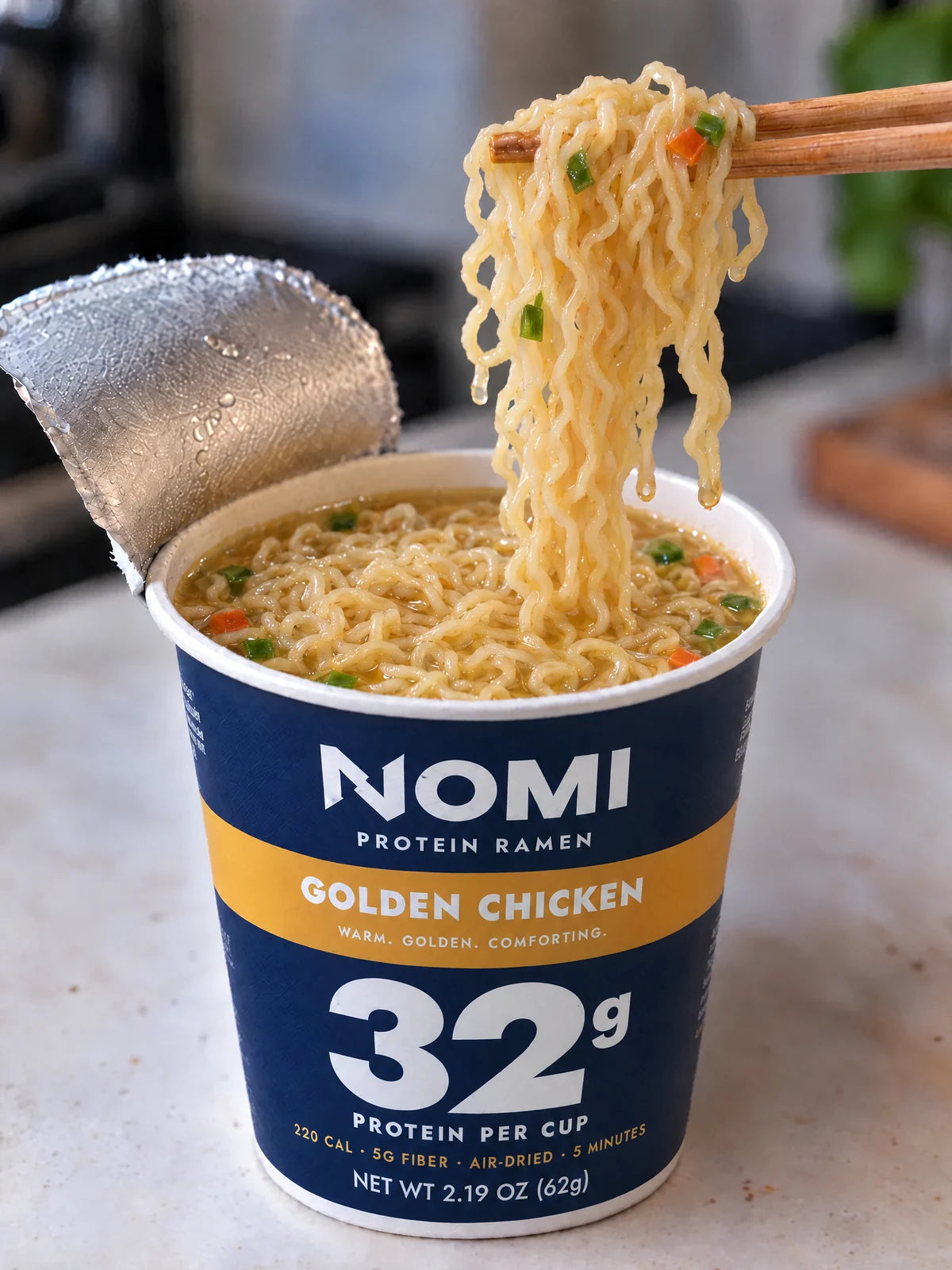 Chopsticks lifting NOMI noodles out of a Golden Chicken cup